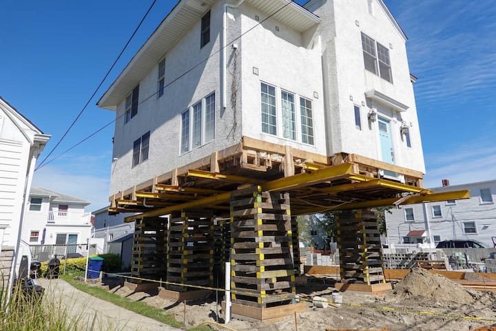 A team of professionals using specialized equipment to raise a house in Duluth, preparing it for elevation and renovation